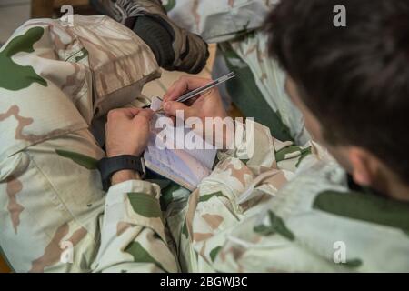 CHAMONIX, FRANKREICH - JANUAR 30: Ein Soldat, der während seiner Pause an der Militärschule in einem Notizbuch schreibt, trainiert die zukünftigen Alpinjäger Stockfoto