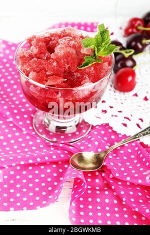 Nahaufnahme von Kirsche Granita in Glasschale, auf farbigen Holzhintergrund Stockfoto