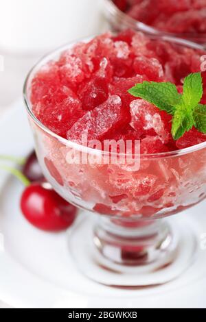 Nahaufnahme von Kirsche Granita in Glasschale, auf farbigen Holzhintergrund Stockfoto