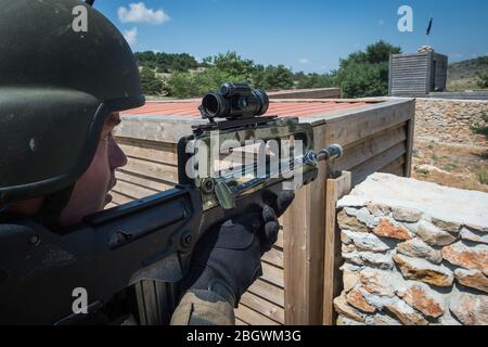 DRAGUIGNAN, FRANKREICH - JULI 21: Ein Mann, der im Rahmen seiner Waffe während einer Simulation des Konflikts zwischen Soldaten und Teroristen mit gefälschten Leichen anvisiert Stockfoto