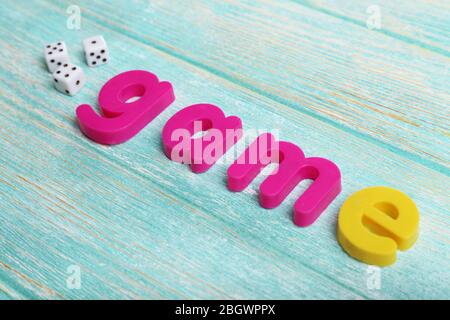 Spiel Wort mit bunten Buchstaben auf Holzhintergrund gebildet Stockfoto