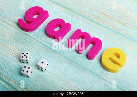 Spiel Wort mit bunten Buchstaben auf Holzhintergrund gebildet Stockfoto