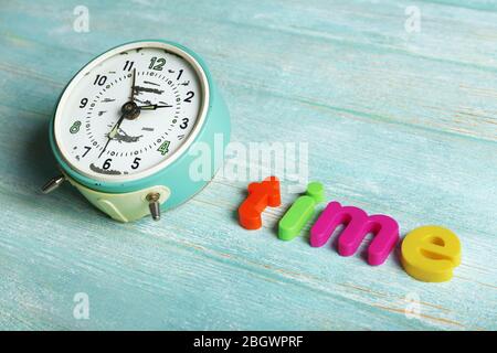Zeitwort mit bunten Buchstaben auf Holzhintergrund gebildet Stockfoto