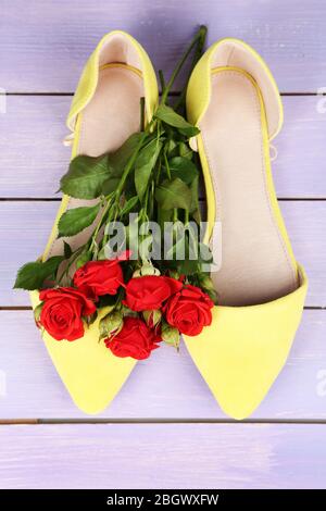 Schöne Damenschuhe mit Blumen auf Holzhintergrund Stockfoto