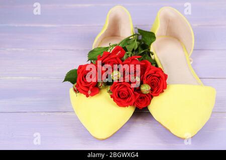 Schöne Damenschuhe mit Blumen auf Holzhintergrund Stockfoto