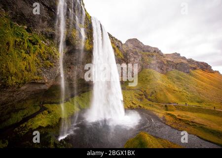 Seljalandsfoss ist einer der bekanntesten Wasserfälle Islands, der einen Weg hinter den Wasserfall führt Stockfoto