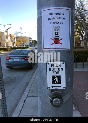 Fußgängerüberweg-Taste aktualisiert mit Covid 19 Schild sagt keine Notwendigkeit, Taste in Culver City, CA zu drücken Stockfoto