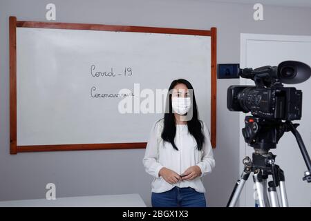 Oliveira, MG / Brasilien - 2020-04-08: Lehrer mit Atemschutzmaske während der Präsentation der Online-virtuellen Klasse Stockfoto