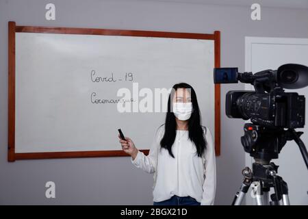 Oliveira, MG / Brasilien - 2020-04-08: Lehrer mit Atemschutzmaske während der Präsentation der Online-virtuellen Klasse Stockfoto