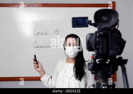 Oliveira, MG / Brasilien - 2020-04-08: Lehrer mit Atemschutzmaske während der Präsentation der Online-virtuellen Klasse Stockfoto