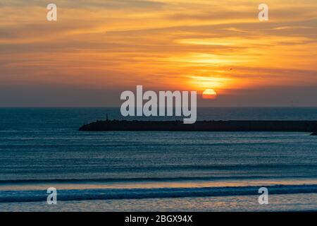 Sonnenuntergang am Strand in Essaouira Marokko in der Nähe des Horizonts mit Wellen Stockfoto