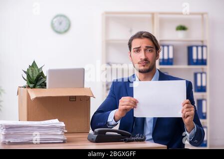 Junger Mann, der von seinem Arbeitsplatz aus gefeuert wird Stockfoto