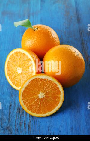 Reife Mandarinen und Orangen mit Blättern auf Holzhintergrund Stockfoto