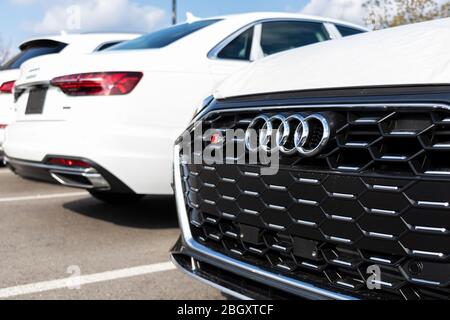 Nahaufnahme des Audi Emblem-Logos auf einem Neuwagen, der bei einem Autohaus abgestellt wird. Stockfoto