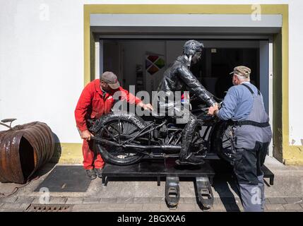 Dorfhain, Deutschland. April 2020. Mitarbeiter der gemeinnützigen Stiftung Georado transportieren eine Skulptur aus Altmetall in Ausstellungsräume. Die Stiftung setzt auch auf Kunst, um die Region zu bereichern. Dazu wurde das Geoart-Netzwerk geschaffen, das Künstler mit dem Publikum und Skulpturen verbindet. Für eine Messe, die aufgrund der Corona-Krise nicht in ihrer ursprünglichen Form stattfinden kann, hat die Stiftung Teile der "Giganten des Stahls", Skulpturen aus tausenden einzelnen Schrott-Stücken, nach Dorfhain gebracht. Quelle: Robert Michael/dpa-Zentralbild/dpa/Alamy Live News Stockfoto