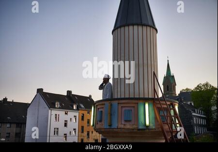 Wuppertal, Deutschland. April 2020. Mustafa Akkaya, religiöser Vertreter der Gemeinde, steht bei Sonnenuntergang auf dem Minarett der Ditib Zentralmoschee. Für die Zeit der Corona-Beschränkungen gibt es eine Ausnahme für den täglichen Muezzin-Aufruf in Wuppertal. Der Fastenmonat Ramadan beginnt unter schwierigen Umständen und großen Einschränkungen aufgrund der Corona-Pandemie. (Zu dpa: 'Ausnahme Ramadan: Corona-Anstrengung und kluge Ideen') Quelle: Bernd Thissen/dpa/Alamy Live News Stockfoto