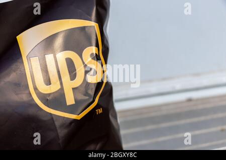 United Parcel Service (UPS) Logo auf einem Paket, das an eine Haustür geliefert wird. Stockfoto