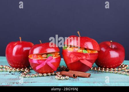Weihnachten rote Äpfel mit getrockneten Früchten auf Farbe Holztisch und dunklen Hintergrund gefüllt Stockfoto