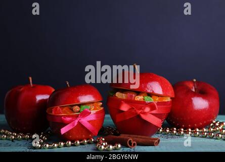 Weihnachten rote Äpfel mit getrockneten Früchten auf Farbe Holztisch und dunklen Hintergrund gefüllt Stockfoto