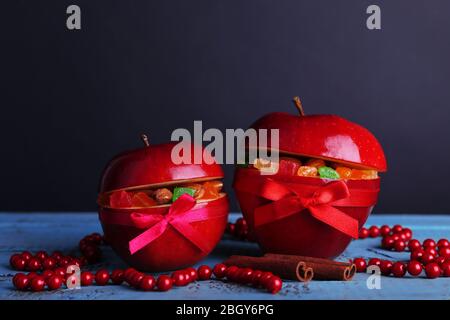 Weihnachten rote Äpfel mit getrockneten Früchten auf Farbe Holztisch und dunklen Hintergrund gefüllt Stockfoto