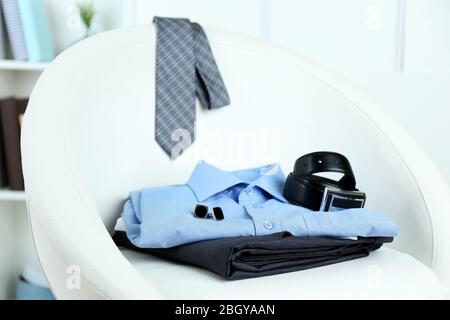 Herrenbekleidung auf Stuhl mit Regal auf Hintergrund Stockfoto