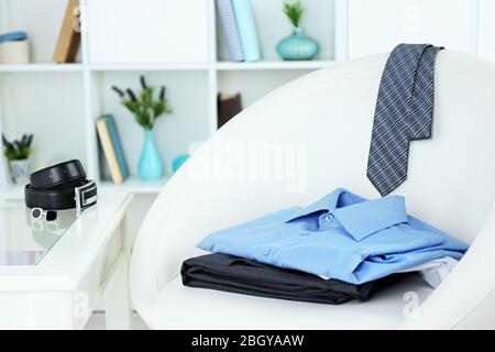 Herrenbekleidung auf Stuhl mit Regal auf Hintergrund Stockfoto