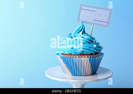 Köstlicher Cupcake mit Inschrift auf blauem Hintergrund Stockfoto