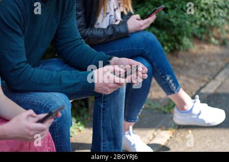Mittelteil der jungen Leute, die das Handy benutzen Stockfoto