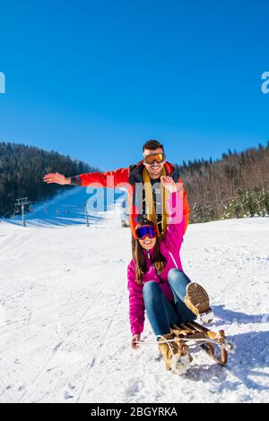 Junge Glücklich Paar Auf Schlitten Spaß Haben Stockfoto