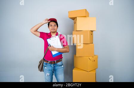 Junge asiatische Männer Delivery Services Tragen Stapel von Paketen und Checkliste Papierzustellung Service-Konzept Stockfoto