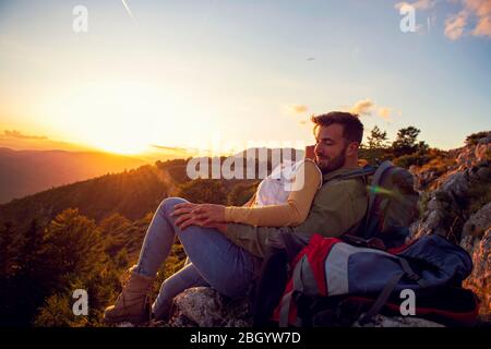 Paar Mann und Frau sitzen auf Klippe genießen Berge und Wolken Landschaft Liebe und Reisen glücklich Emotionen Lifestyle-Konzept. Stockfoto