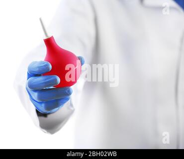 Doktor Hand in Handschuhe mit medizinischen rosa Einlauf Spritze isoliert auf weißem Hintergrund Stockfoto