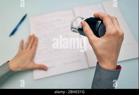 Kleines Mädchen setzt einen Stempel auf Dokumente Stockfoto