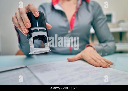 Kleines Mädchen setzt einen Stempel auf Dokumente Stockfoto