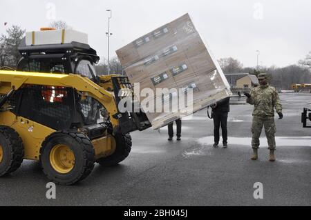 New York Army National Guard Sgt. Wilson Cuevaquiraga, der 133. Quartermaster Company des 53. Truppenkommandos zugewiesen, leitet die Massenverladung von Handdesinfektionsmitteln für lokale Regierungsbehörden in der Nähe von New Rochelle, NY 13. März 2020. Cuevaquiraga und mehr als 250 andere Soldaten und Luftwaffe der New York National Guard unterstützen eine New York State Department of Health Task Force, um den Ausbruch des COVID 19 Virus Cluster in Westchester County, N.Y. US National Guard Foto von Col. Richard Goldenberg einzudämmen und zu mildern. Stockfoto