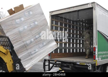 New York Army National Guard Spc. Rolondo Hensen, dem 204. Ingenieurbataillon des 53. Truppenkommandos zugeordnet, leitet die Massenverladung von Handdesinfektionsmitteln für lokale Regierungsbehörden in der Nähe von New Rochelle, NY, 13. März 2020. Hensen und mehr als 250 weitere Soldaten und Luftwaffe der New York National Guard unterstützen eine New York State Department of Health Task Force, um den Ausbruch des COVID 19-Virus-Clusters im Westchester County, New York, einzudämmen. Foto der U.S. National Guard von Col. Richard Goldenberg. Stockfoto