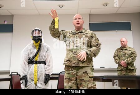 Mitglieder des WVNG-Battalion (WVNG) der West Virginia National Guard (Chemical, Biological, Radiological, Nuclear and High Yield explosive (CBRNE), des 35th Civil Support Team (CST) und des 35ten CBRN Enhanced Response Force Package (CERFP) bieten Mitgliedern von First Responder Agencies aus Kentucky und West Virginia praktische Anweisungen zur persönlichen Schutzausrüstung (PSA). März 2020 in Huntington, W.Va. Die Just-in-Time-Schulung wurde durchgeführt, um Ersthelfer darüber zu informieren, wie Kreuzkontamination durch den richtigen Verschleiß, das "Donnen" und die Verfahren zum "Doffing" von PSA minimiert werden kann. (USA Stockfoto