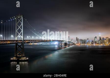 Nachtaufnahme der Skyline von San Francisco mit der Bucht Brücke im Vordergrund von Treasure Island aus gesehen Stockfoto