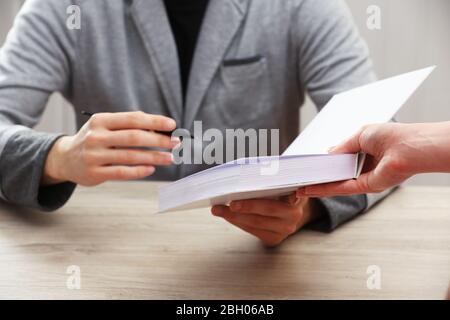 Author Signing Autograph in eigenem Buch am Holztisch auf weißem Plankenhintergrund Stockfoto