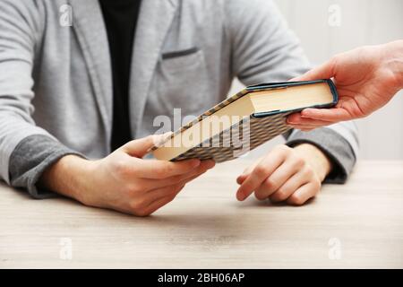 Author Signing Autograph in eigenem Buch am Holztisch auf weißem Plankenhintergrund Stockfoto