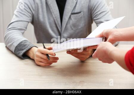 Author Signing Autograph in eigenem Buch am Holztisch auf weißem Plankenhintergrund Stockfoto