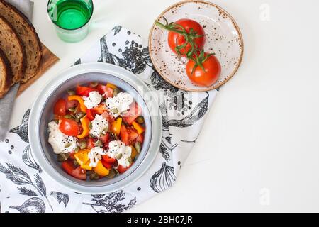 Gesunder Salat mit gegrilltem Pfeffer, Tomaten, Stracciatella, Kräutern und Kürbiskernen. Gesundes Essen Konzept. Stockfoto