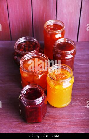 Hausgemachte Gläser von Früchten Marmelade auf Farbe Holzhintergrund Stockfoto