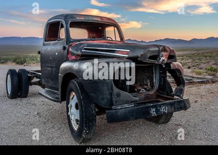 Ein zerstörter und rostiger schwarzer Pickup-Truck in der rhyolitischen Geisterstadt Death Valley bei Sonnenuntergang Stockfoto