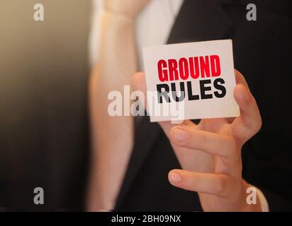 Geschäftsmann mit einer Karte mit Text Grundregeln. Geschäftskonzept Stockfoto