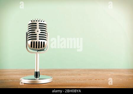 Retro-Mikrofon auf Holztisch auf blauem Hintergrund Stockfoto
