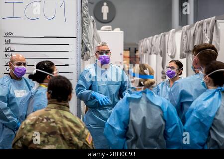 Army Maj. Sean Shirley hält ein Treffen mit Mitarbeitern in der Intensivstation der Javits New York Medical Station (JNYMS) ab. Die Einrichtung, die seit dem 30. März 2020 für nicht-COVID-19-Patienten in Betrieb ist und sich um sie kümmert, begann am 3. April mit der medizinischen Versorgung von Patienten mit dem Virus. Stockfoto