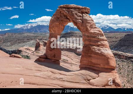 Der berühmte Delicate Arch, Utah, an einem sonnigen Tag gegen schneebedeckte Berge Stockfoto