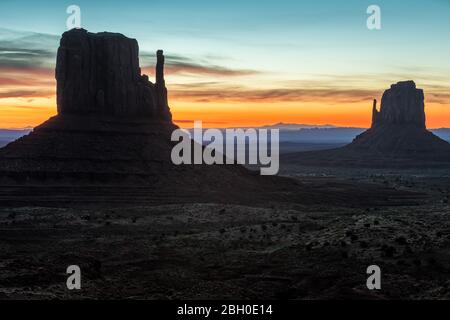 Sonnenaufgang im Monument Valley, mit zwei Felsformationen im Vordergrund Stockfoto