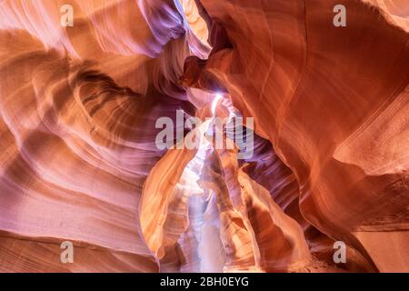 Weitwinkelansicht des Gewölbes des Upper Antelope Canyon, mit einem Lichtstrahl, der aus einer Öffnung einbricht Stockfoto